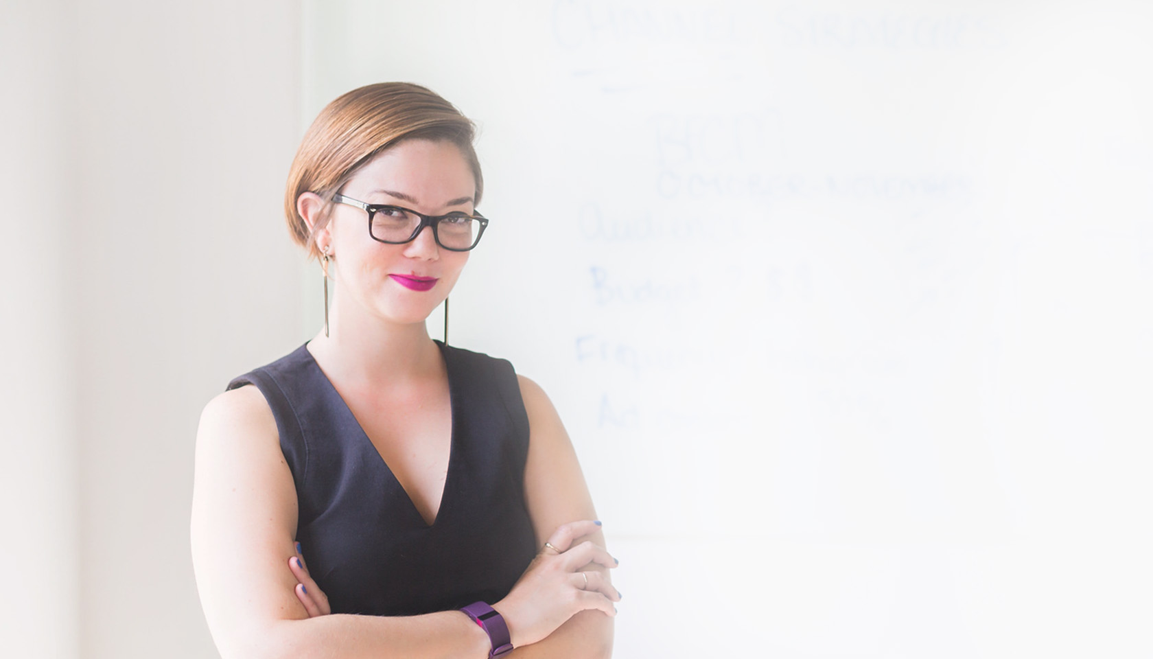 Confident woman wearing glasses and a black sleeveless top.