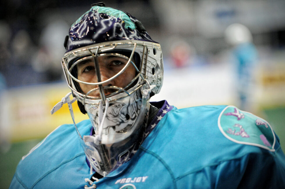 Hockey goalie in blue uniform and mask.